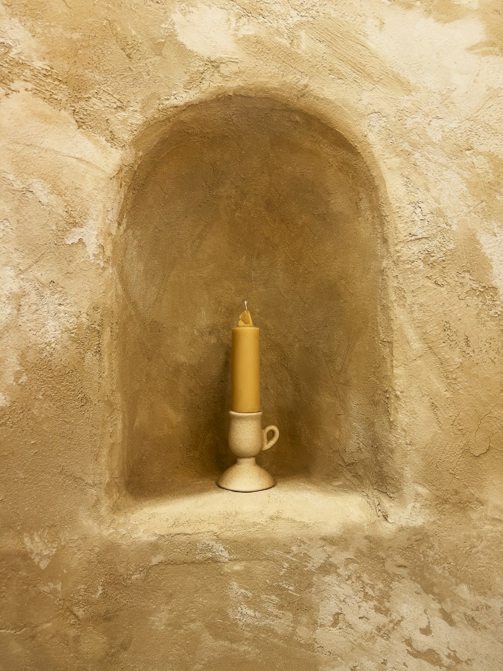 um vaso branco sentado em cima de uma parede de pedra
