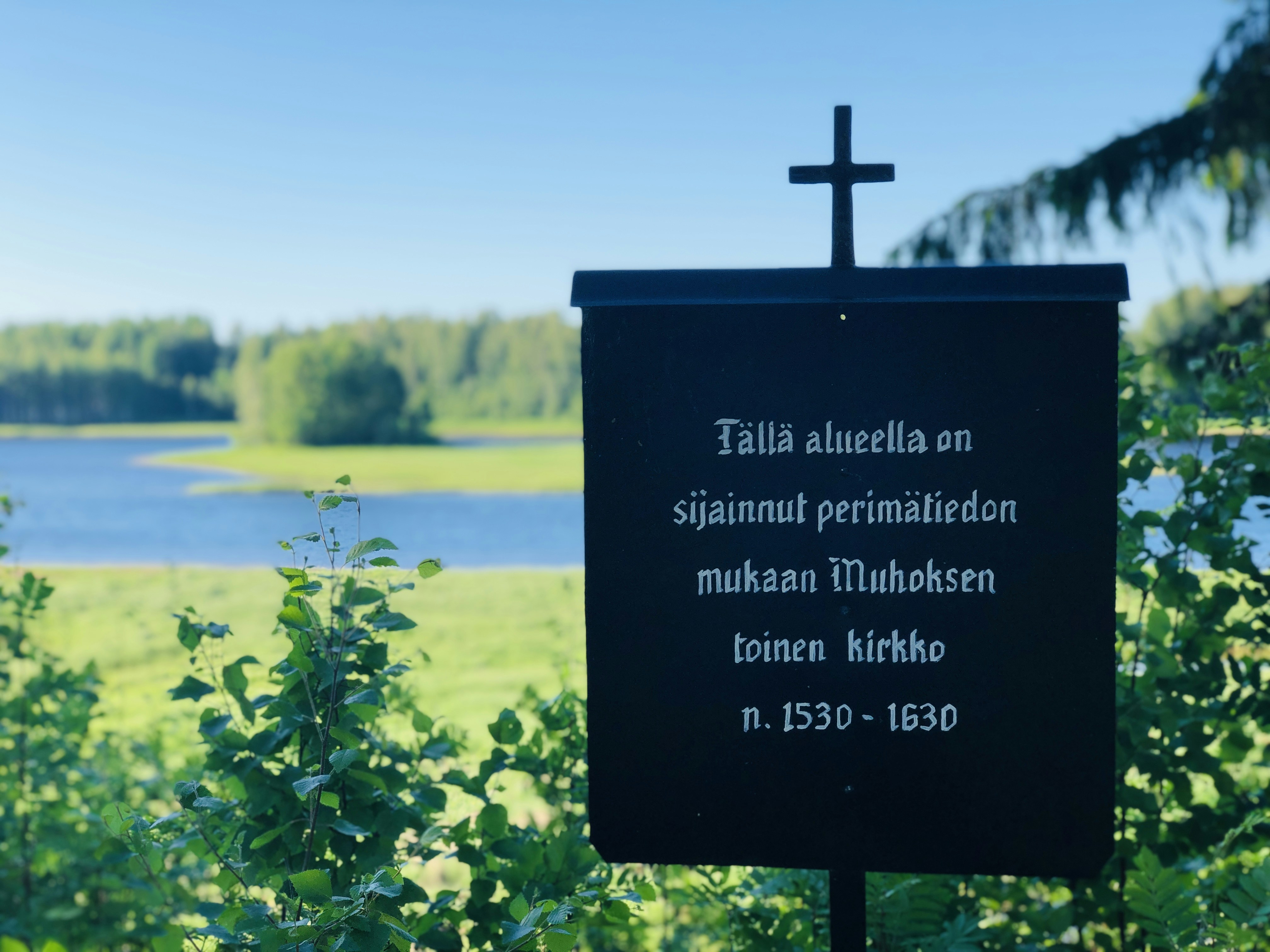a black sign with a cross on top of it