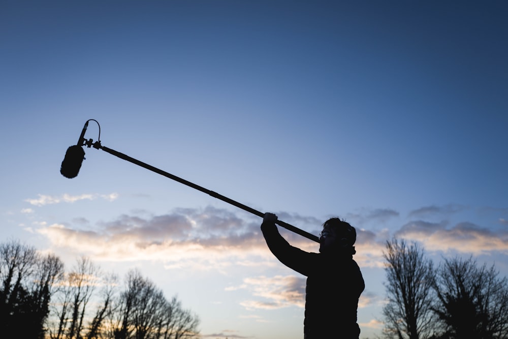 un homme tenant un poteau avec une lumière attachée à celui-ci