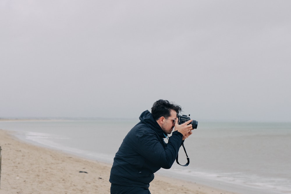 um homem tirando uma foto de si mesmo na praia