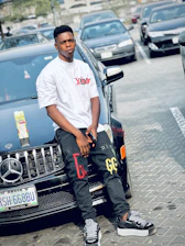 A young entrepreneur smiling confidently while holding a football and a smart car gadget.