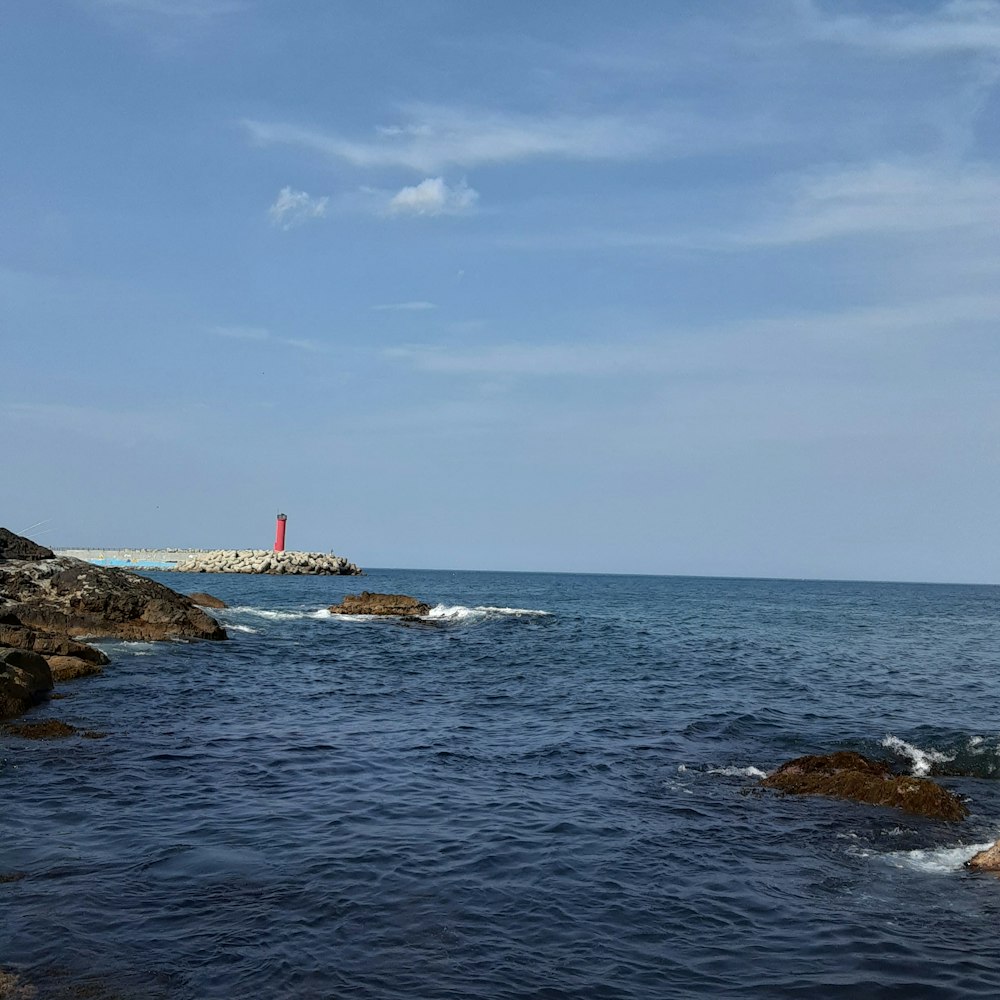 a lighthouse on a rock outcropping in the ocean