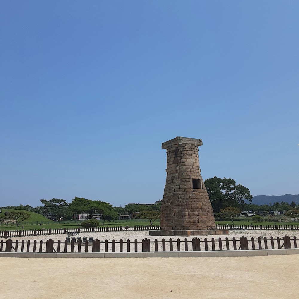 a tall brick tower sitting on the side of a road