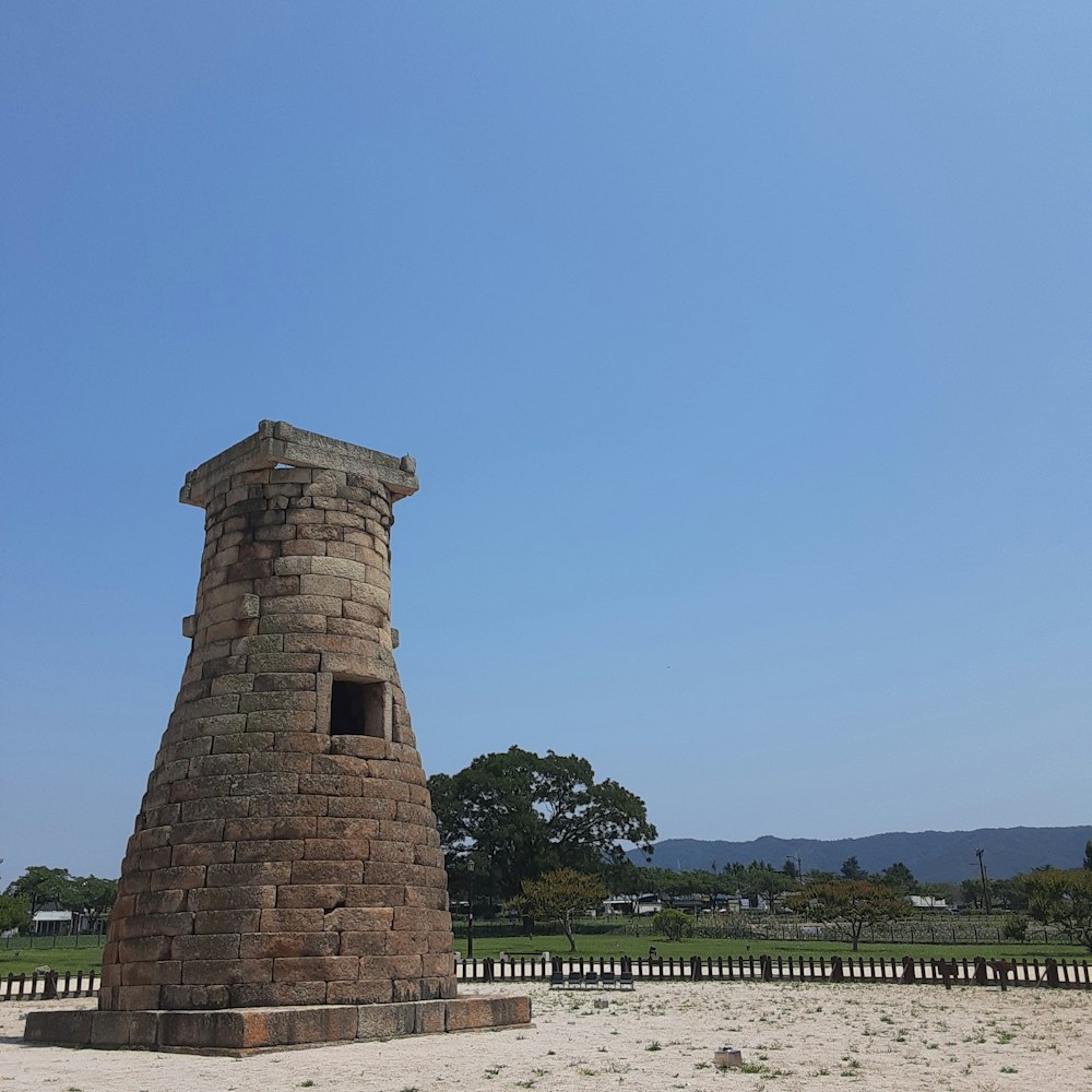 a stone tower sitting in the middle of a field