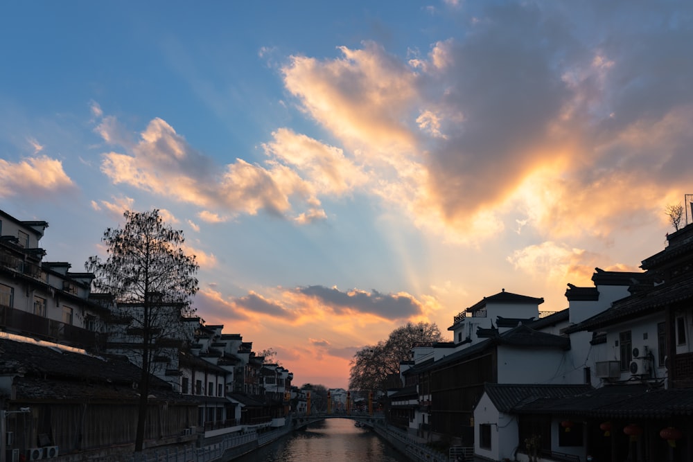 a river running through a city under a cloudy sky