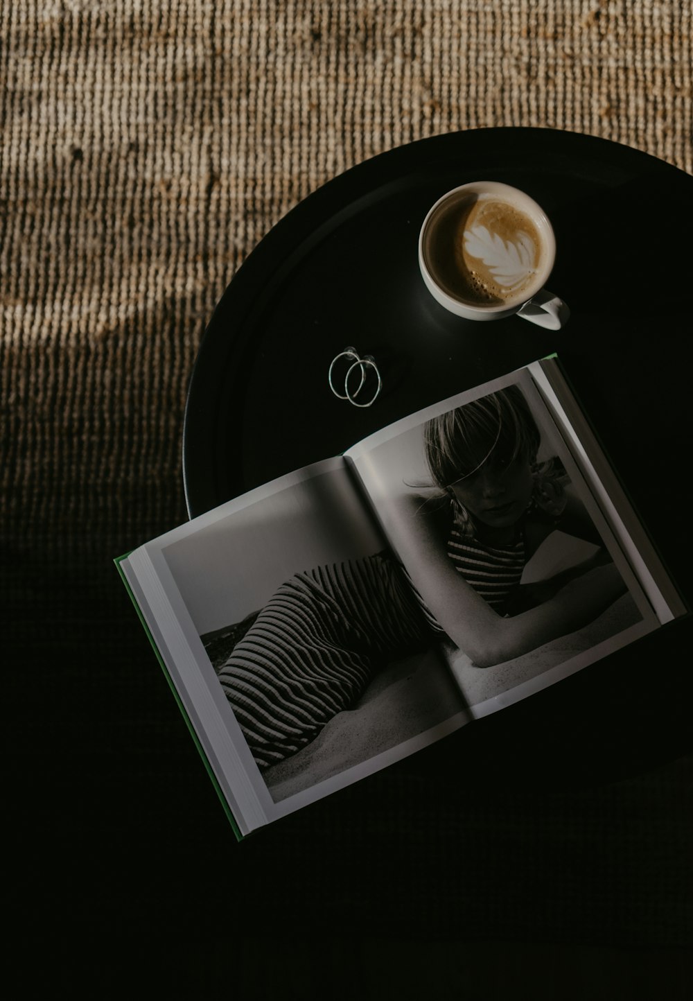 an open book sitting on top of a table next to a cup of coffee