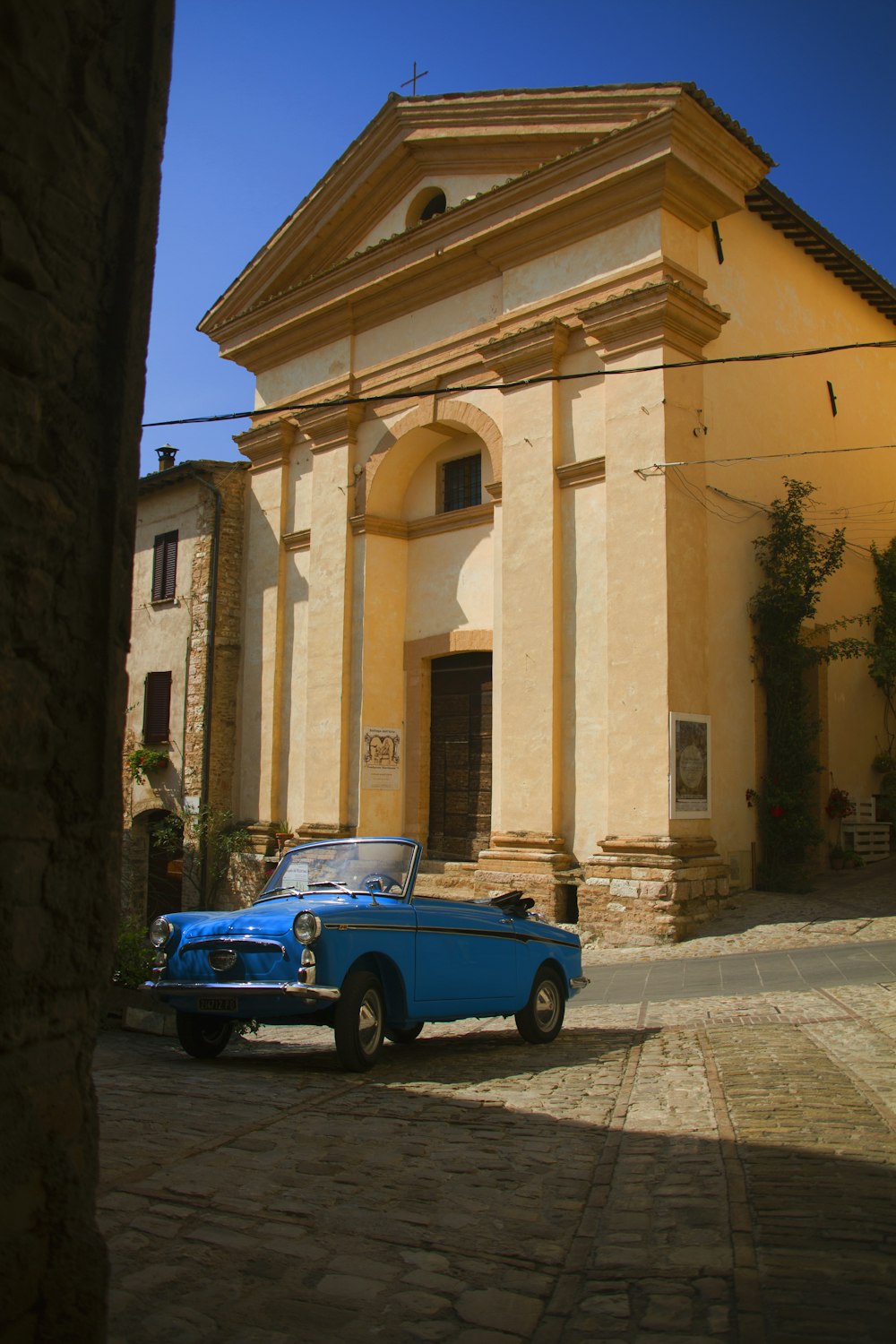 a blue car parked in front of a building