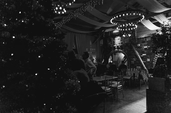 A warmly lit restaurant room with large tables set for a festive family celebration, filled with laughter and colorful decorations.