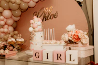 a table topped with a cake and lots of balloons
