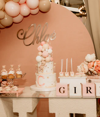 A colorful gift basket filled with balloons, plush toys, and personalized name tags arranged for a baby shower.