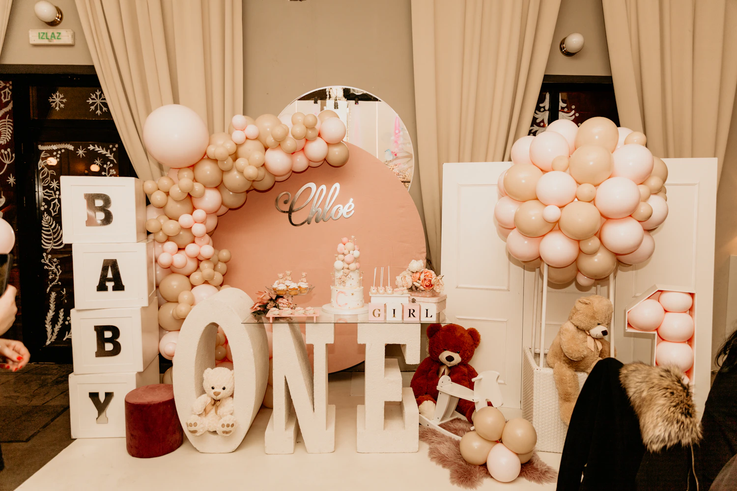 Birthday dessert table framed by balloons and soft decorative details