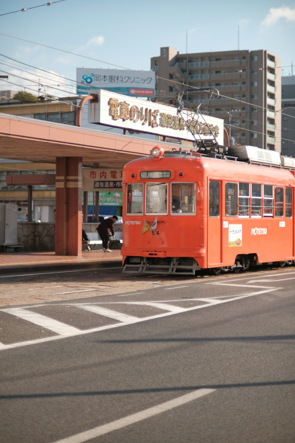 an orange trolley is parked on the side of the road