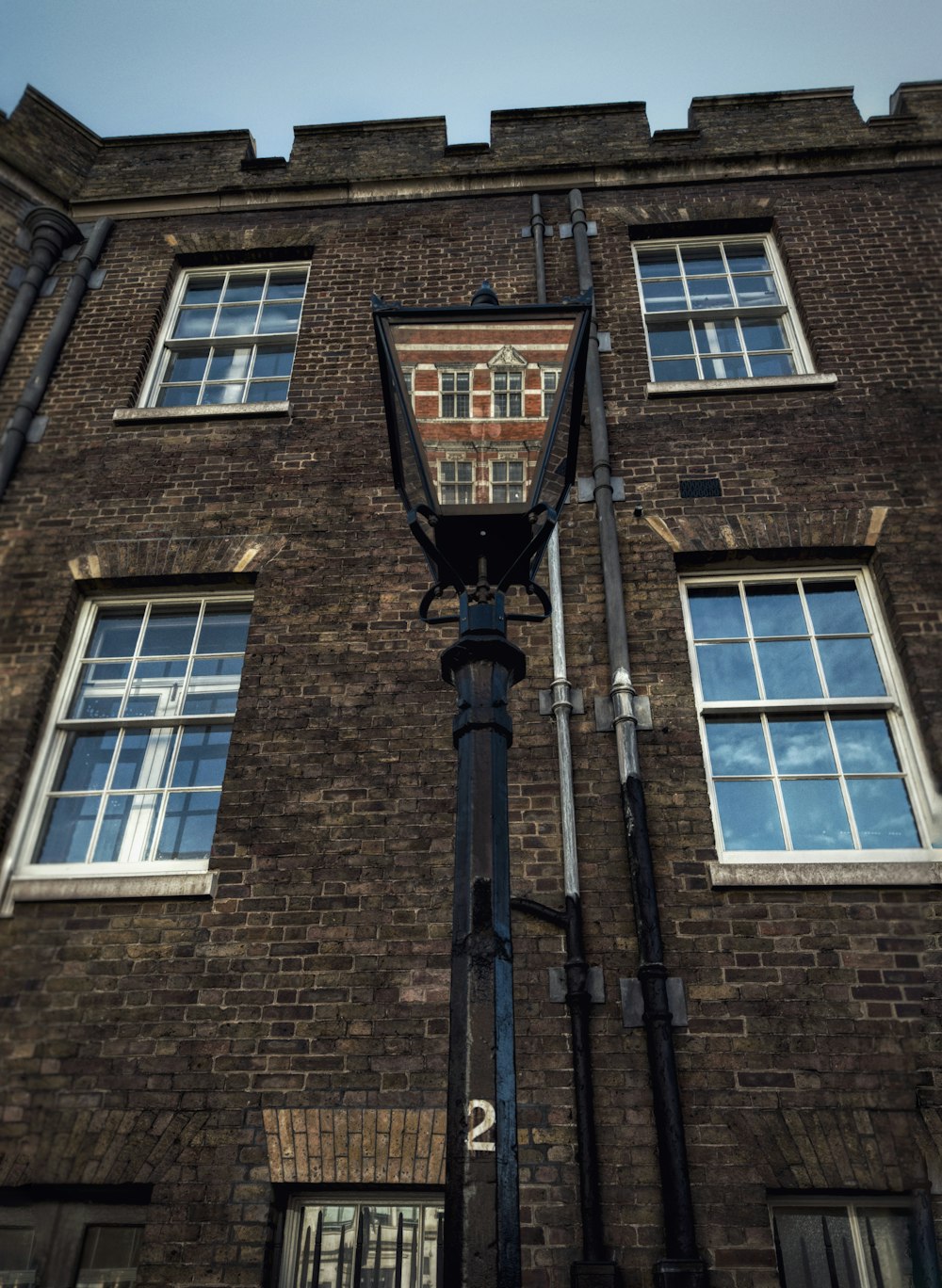 a lamp post in front of a brick building