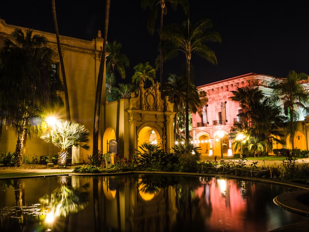 a building with a pool in front of it at night