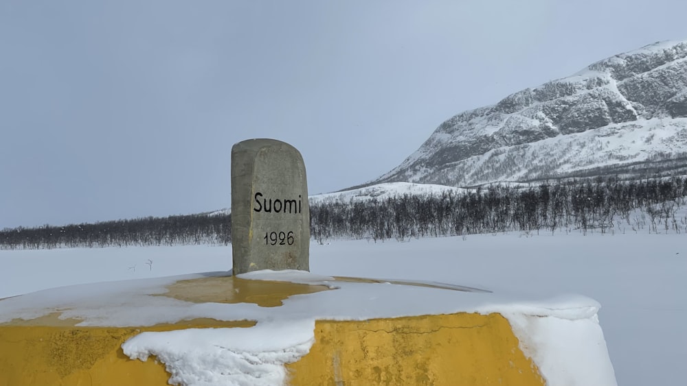 a grave in the snow with a mountain in the background