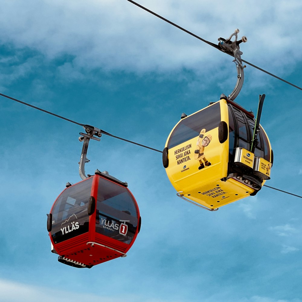 a yellow and red cable car and a red and black cable car