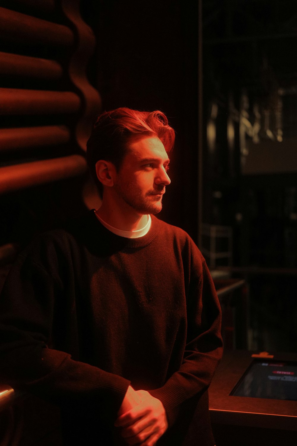 a man with red hair sitting in a dark room