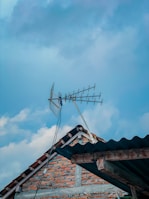 An outdoor scene showing a LoRa antenna mounted on a rooftop against a clear blue sky