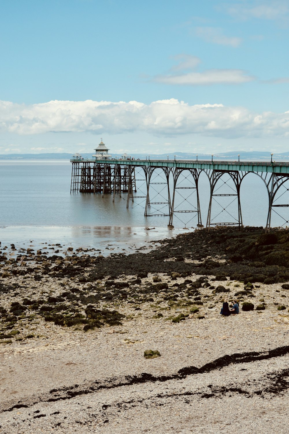 a wooden pier sitting on top of a sandy beach