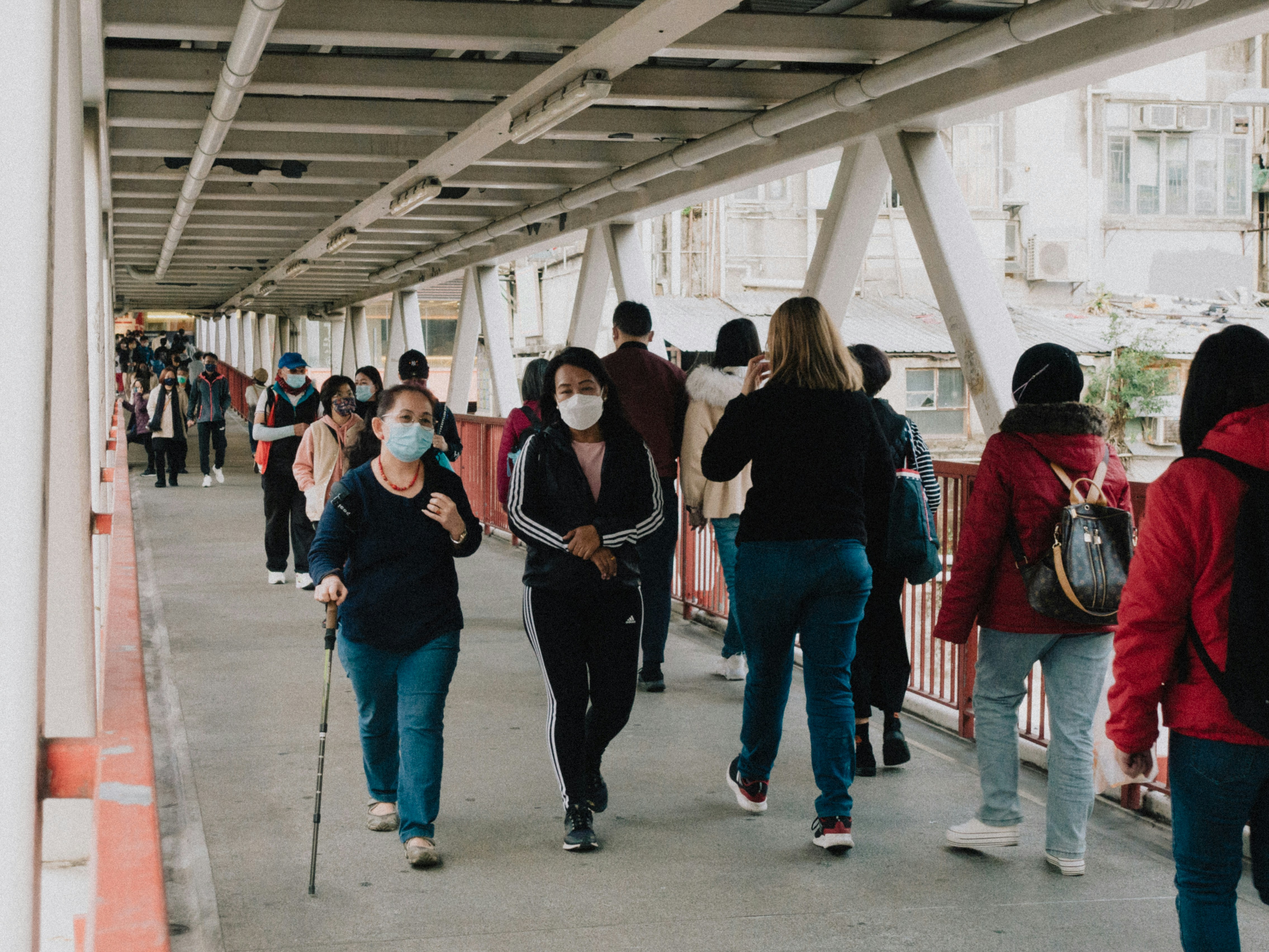 A group of people walking across a bridge photo – Free City Image on ...