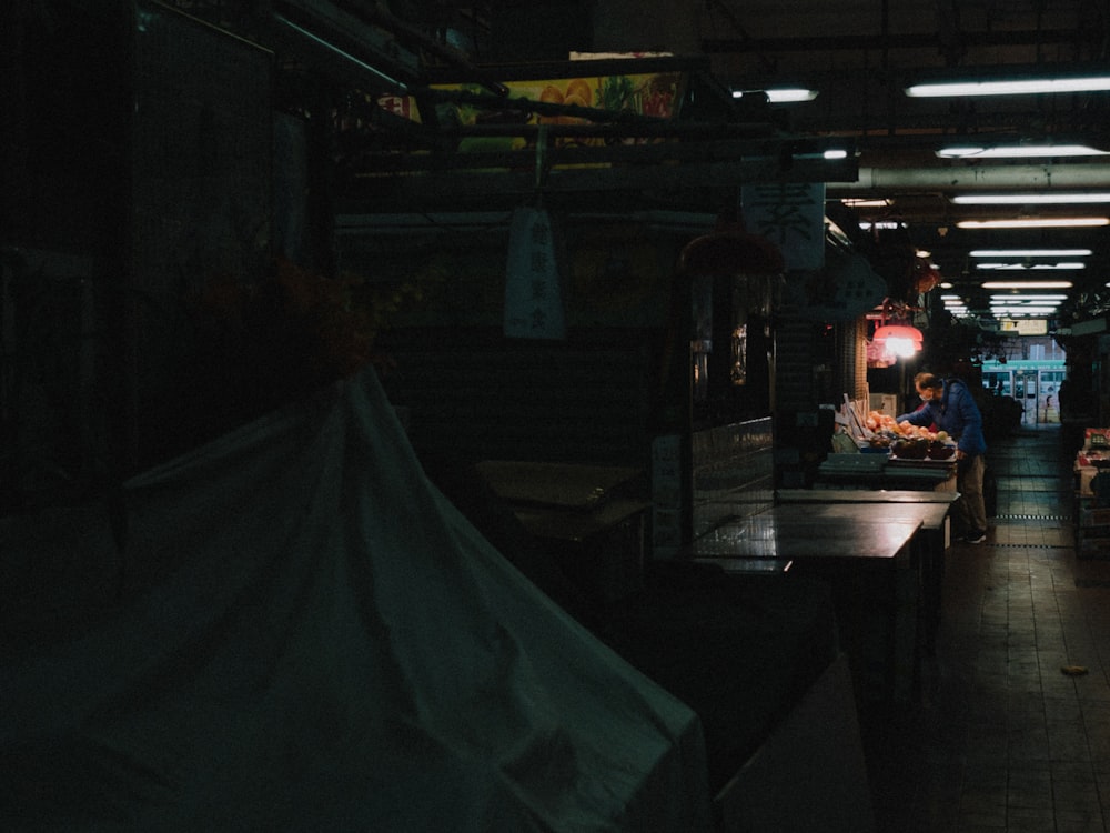 a man standing in a dark room next to a table