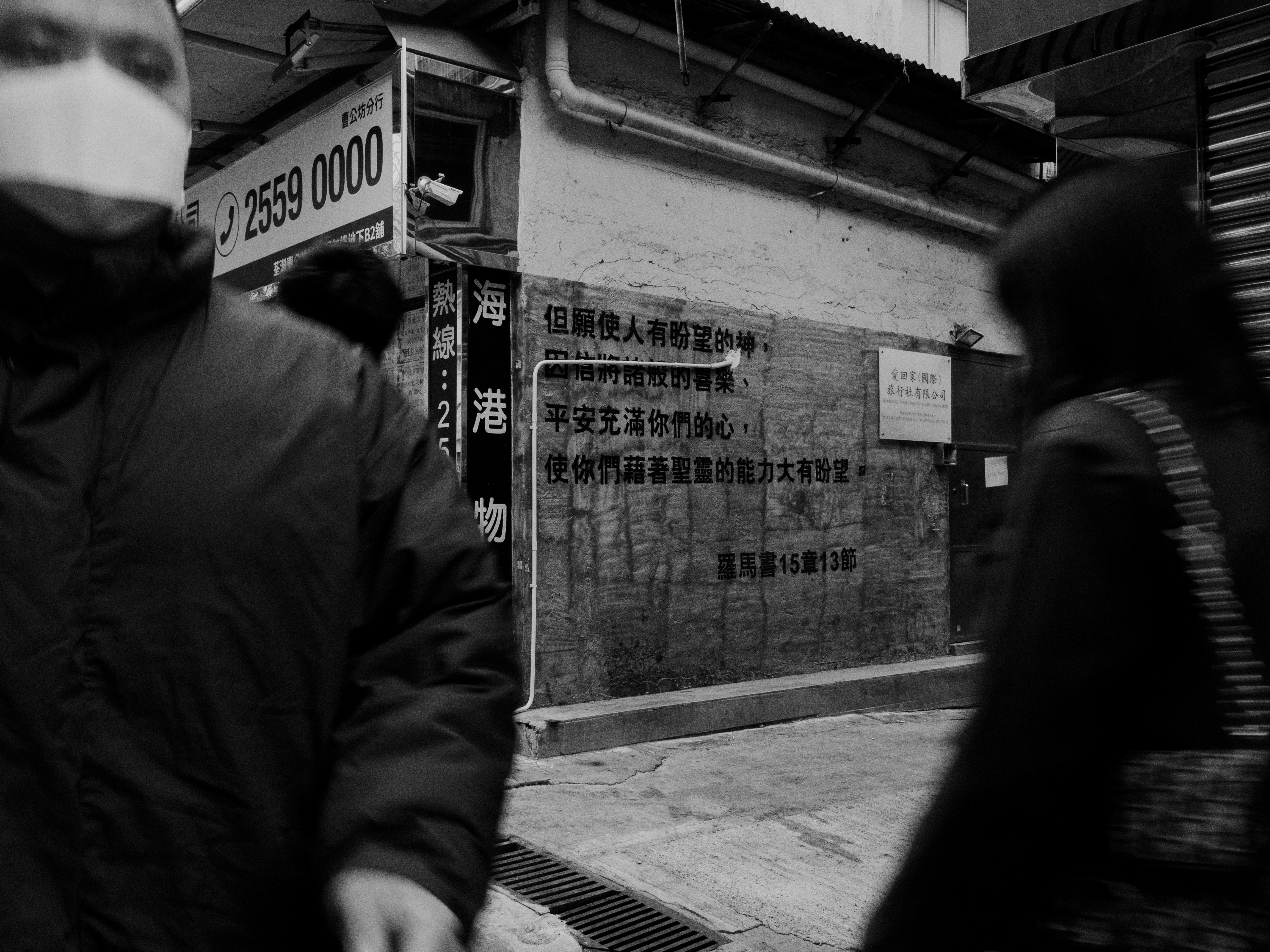 A man walking down a street next to a tall building