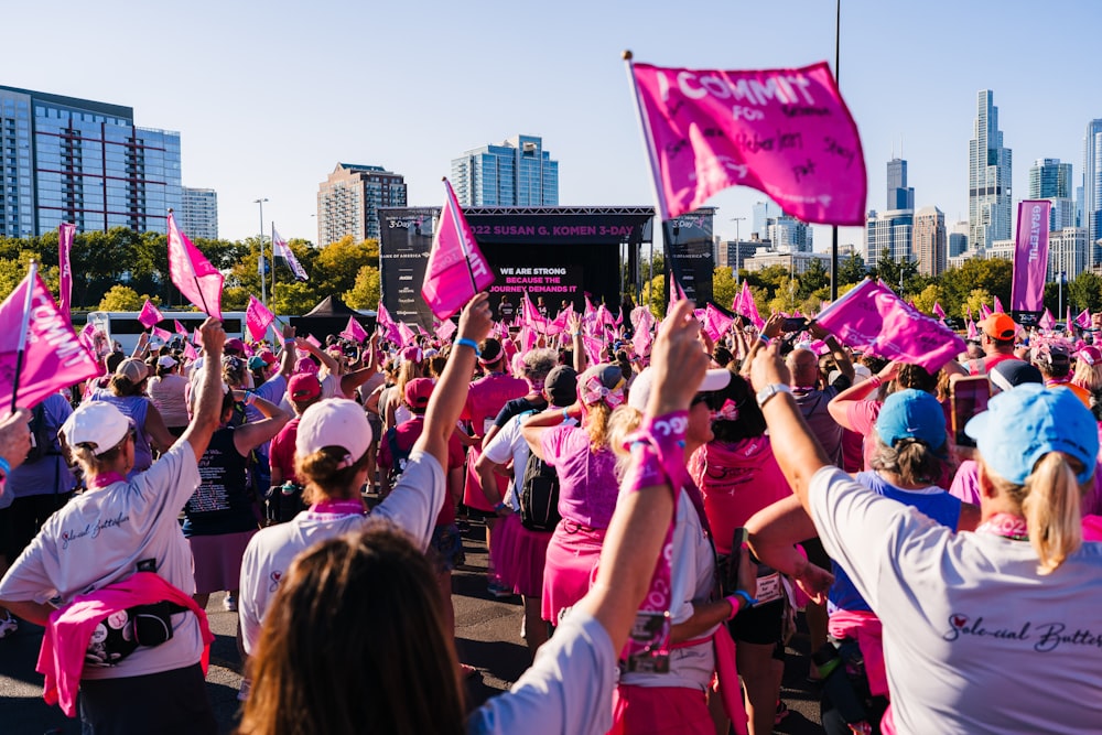 um grande grupo de pessoas com bandeiras cor-de-rosa