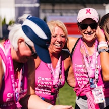 a group of women in pink shirts and hats