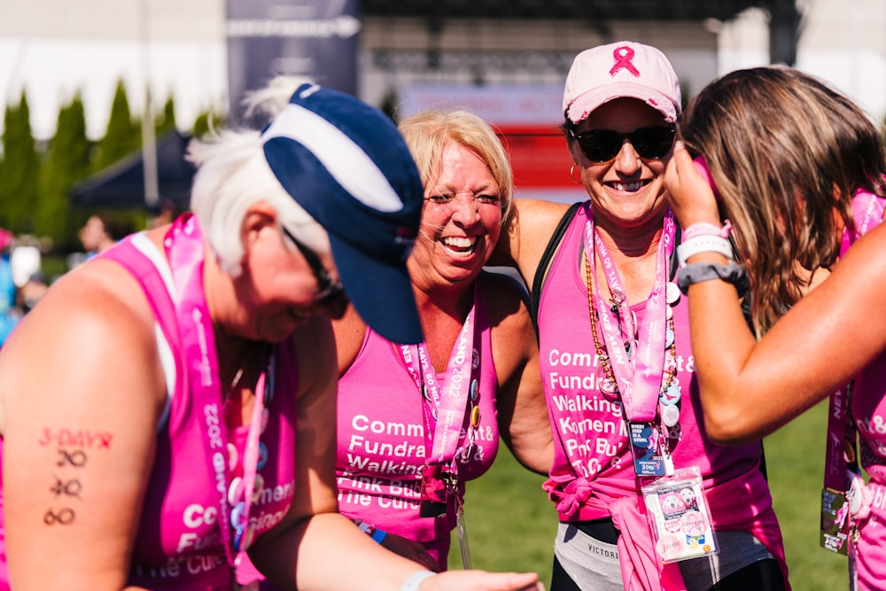 um grupo de mulheres em camisas e chapéus cor-de-rosa