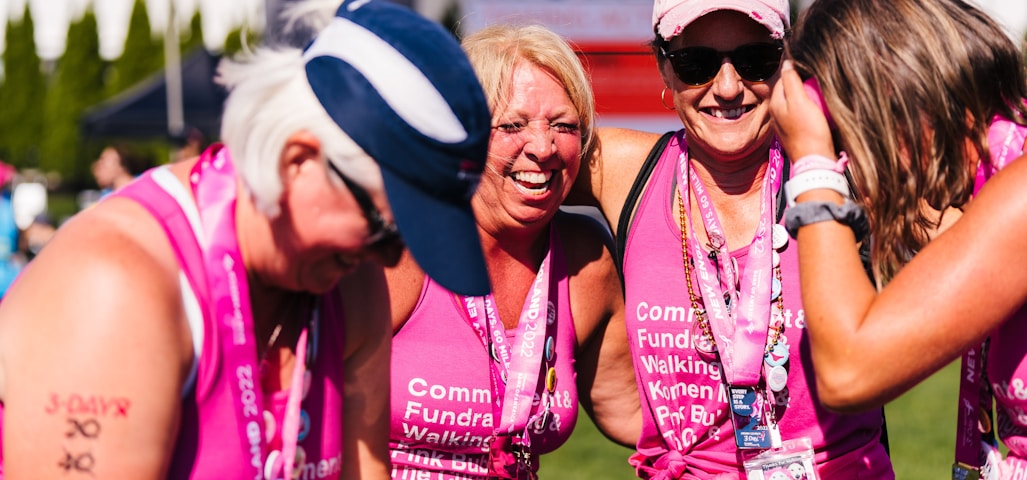 a group of women in pink shirts and hats