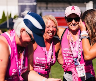 a group of women in pink shirts and hats