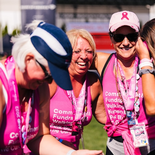 a group of women in pink shirts and hats