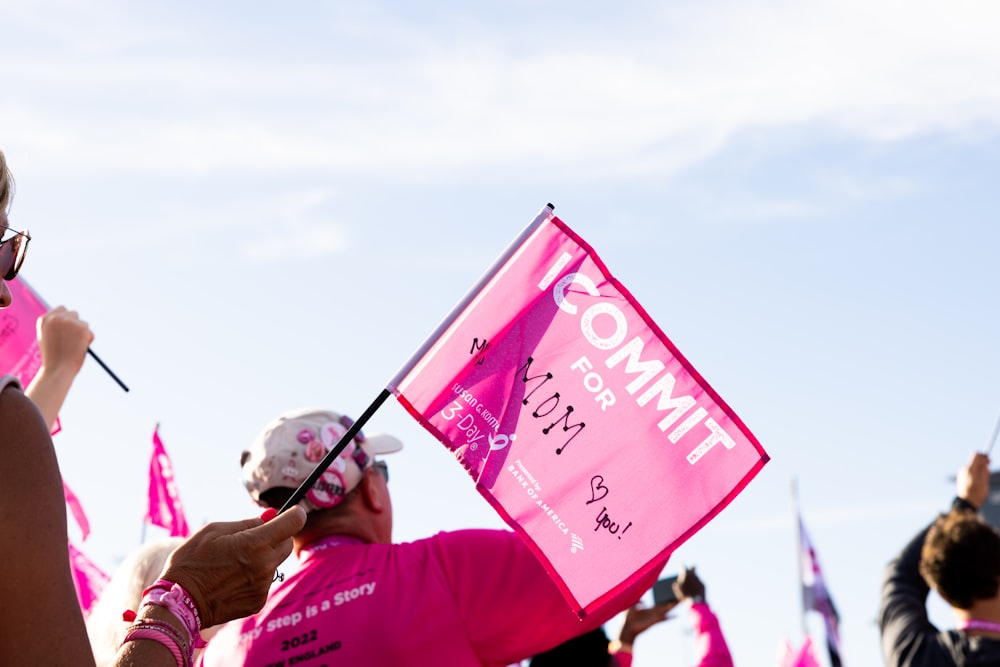 Un grupo de personas con banderas rosadas y carteles