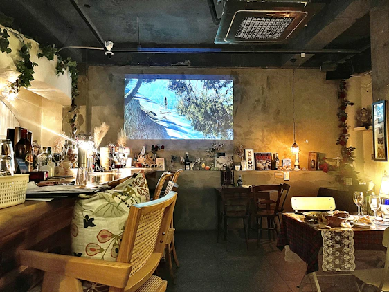 Cozy Scandinavian-style restaurant interior with warm lighting and a team planning digital content around a wooden table.
