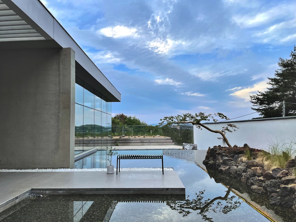 a bench sitting in front of a glass walled pool