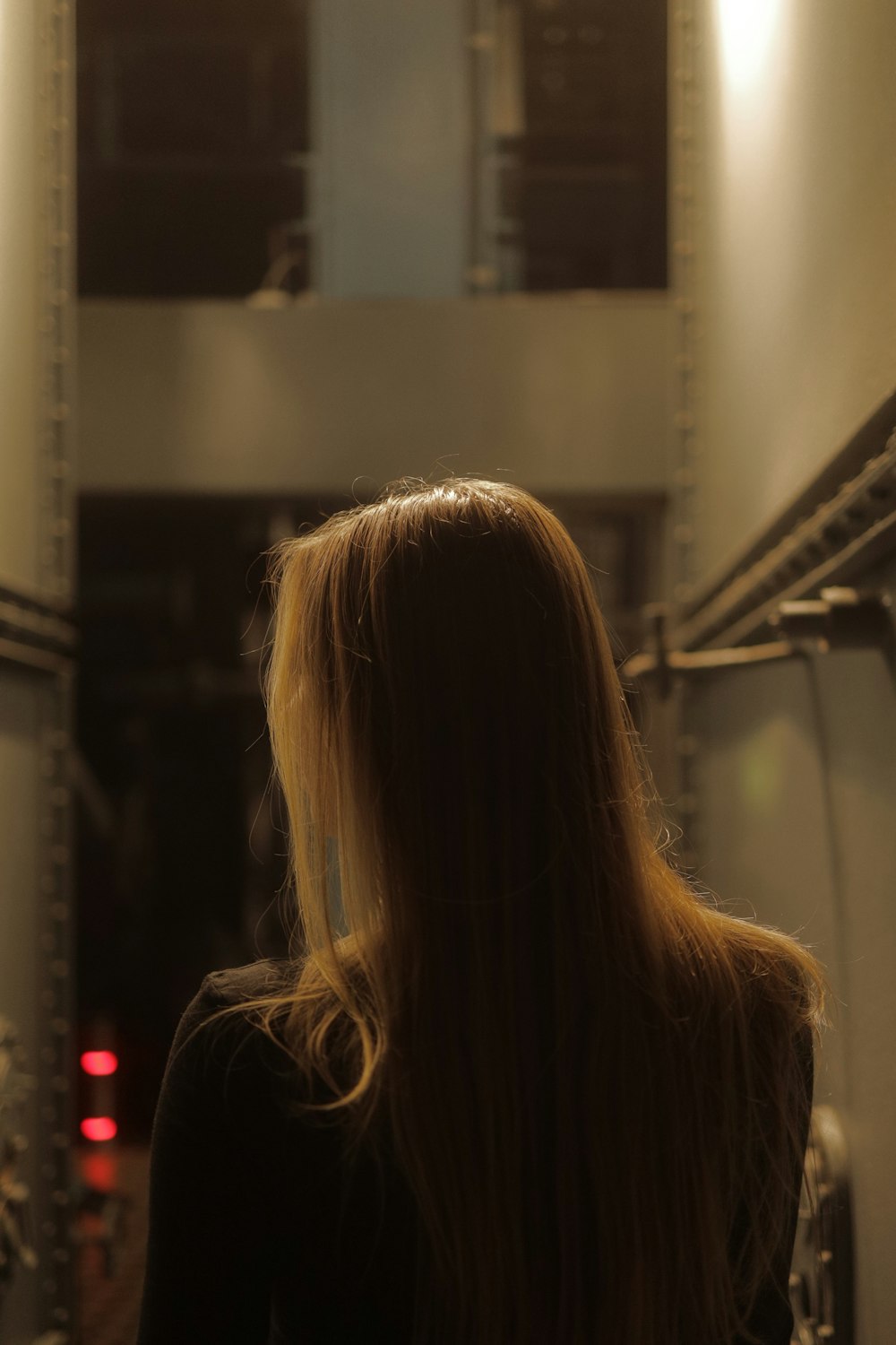 Una mujer con cabello largo y rubio parada en un pasillo