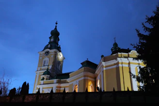 The church building at sunset, glowing warmly against the evening sky.