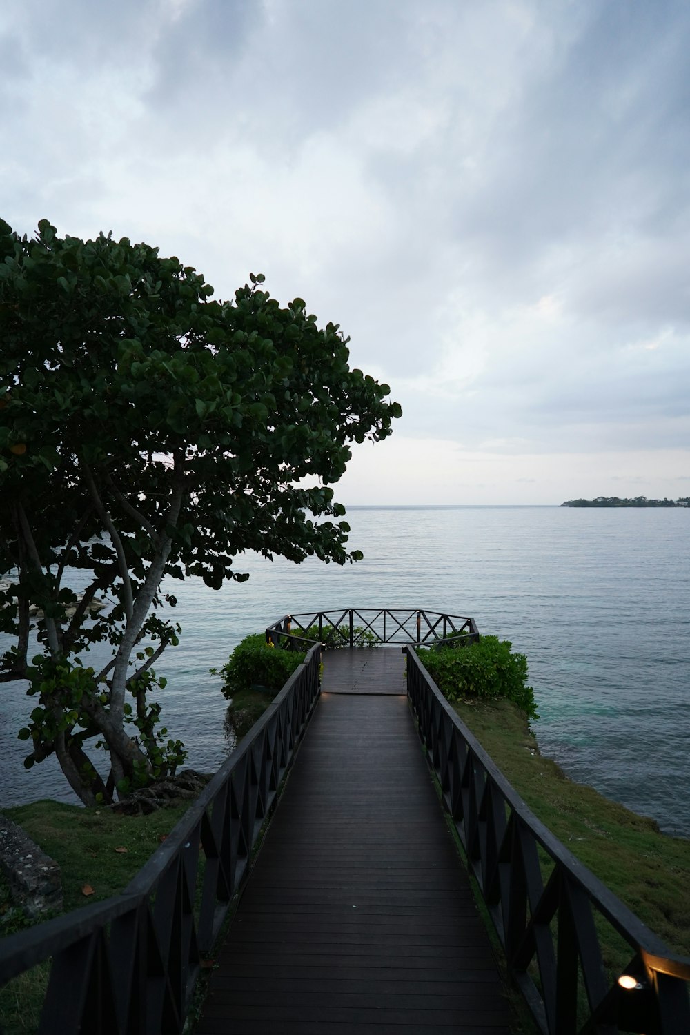 a wooden walkway leading to the ocean at dusk