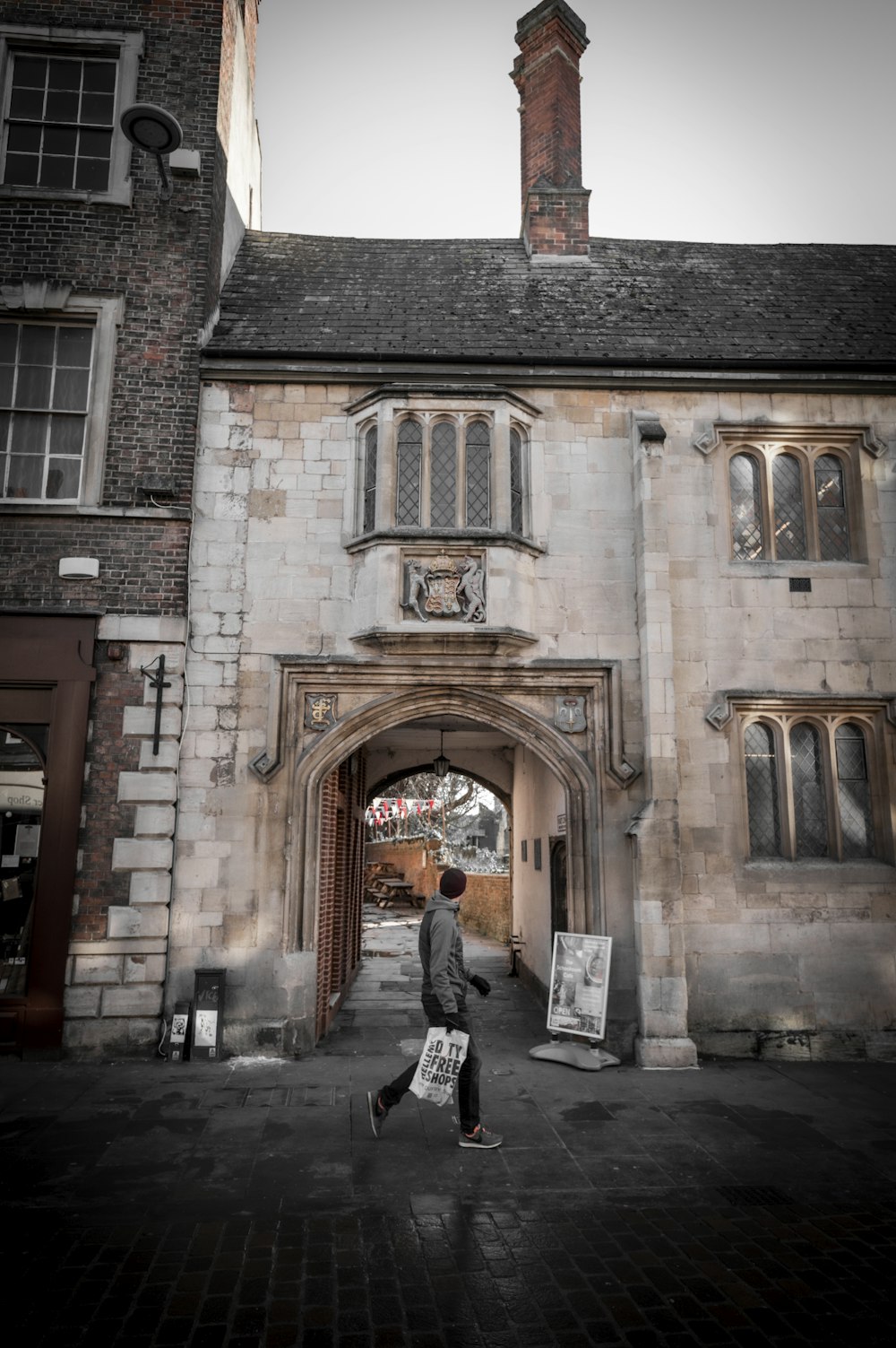 a man walking down a street in front of a building