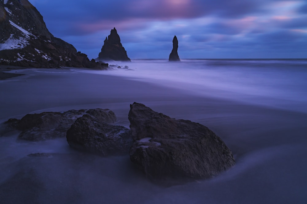 a long exposure photo of a rock formation in the ocean