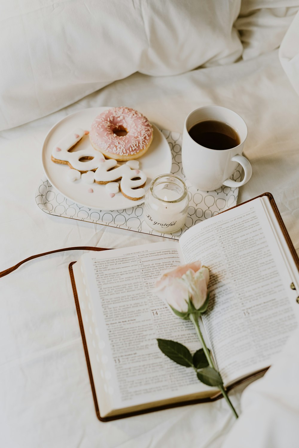 a cup of coffee and a doughnut on a tray