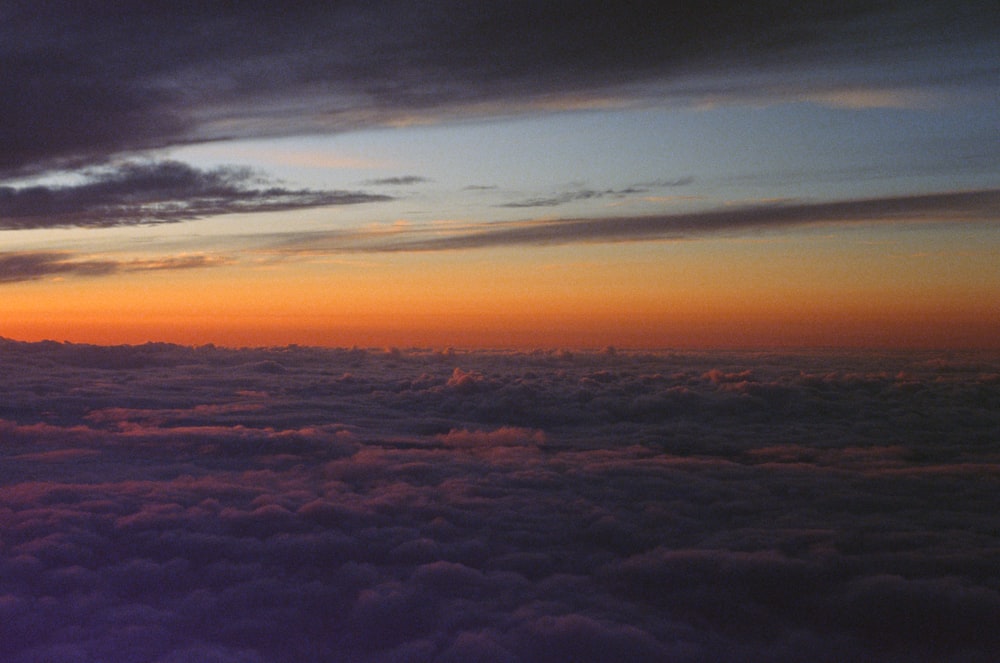 the sun is setting over the clouds in the sky