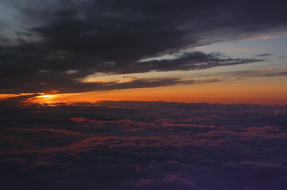 the sun is setting over the clouds in the sky