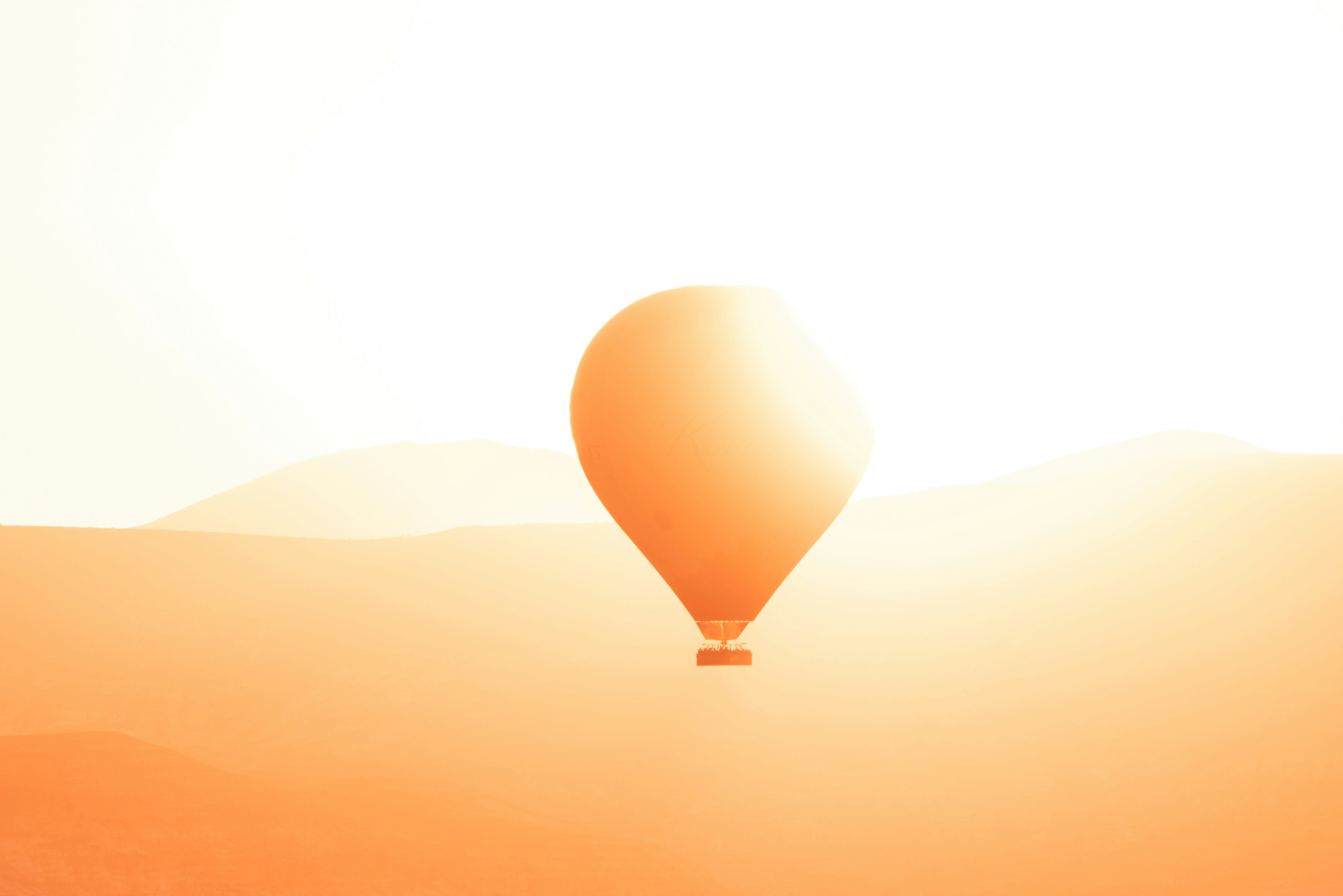 a hot air balloon flying in the sky, Single hot air balloon at sunrise in Cappadocia, Turkey