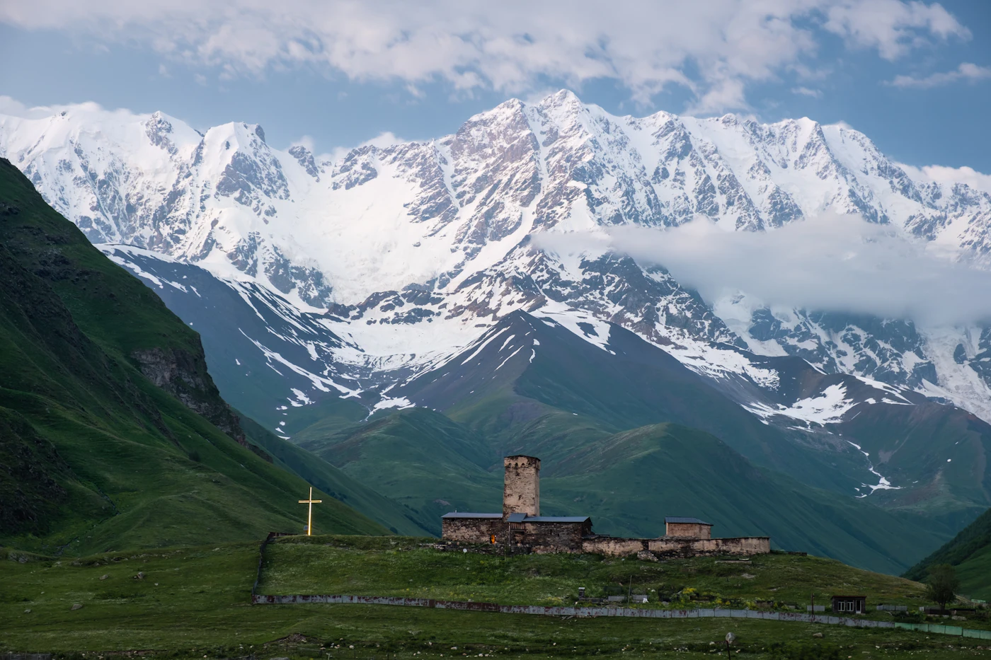 Stone church in front of the snow-capped Caucasus ridge in Svaneti