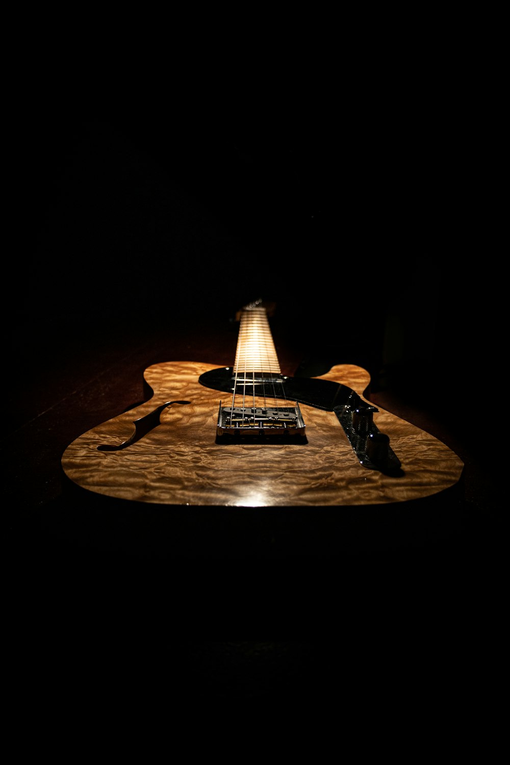 a guitar sitting on top of a wooden table