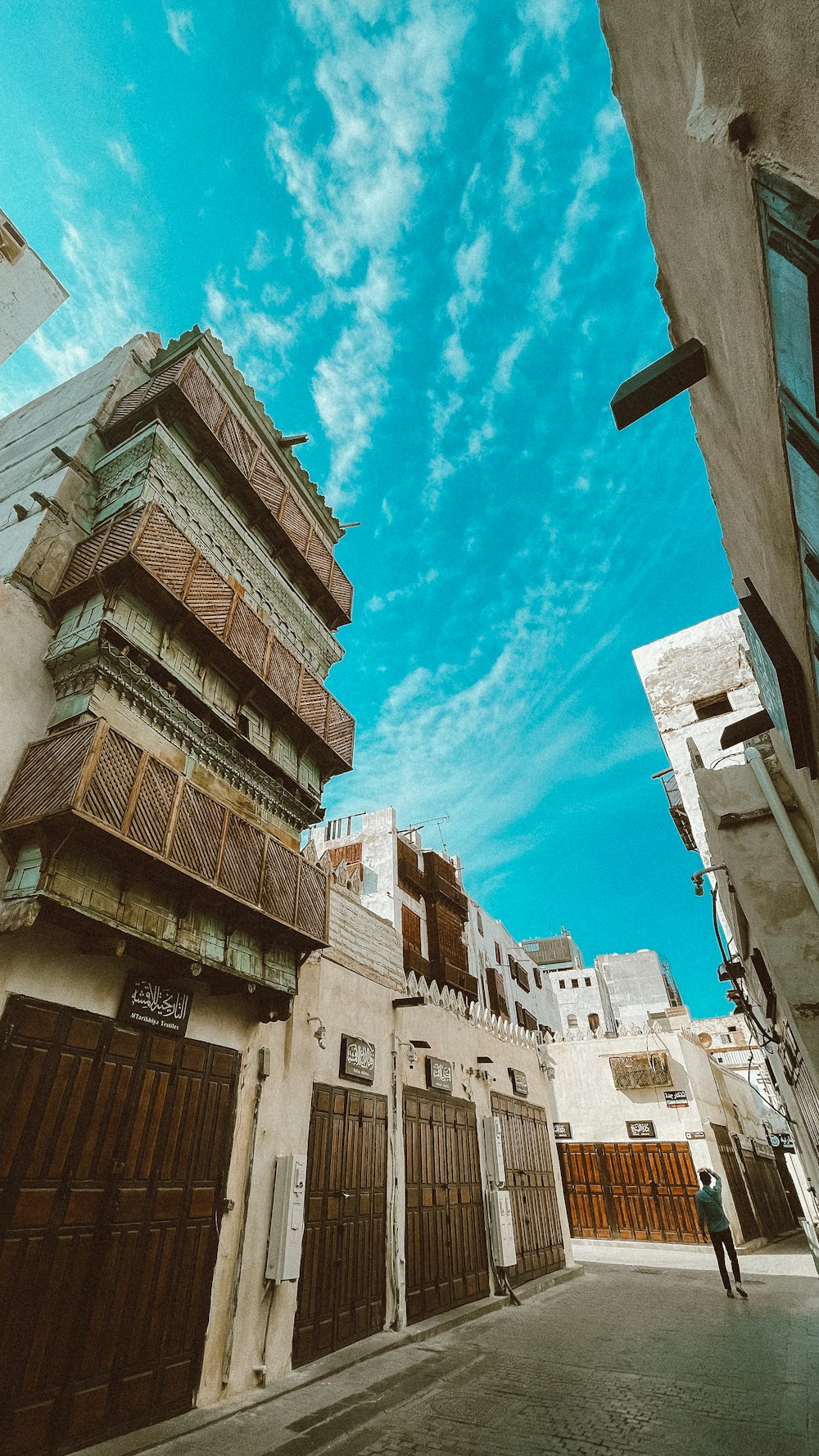 a narrow street with a building and a sky background