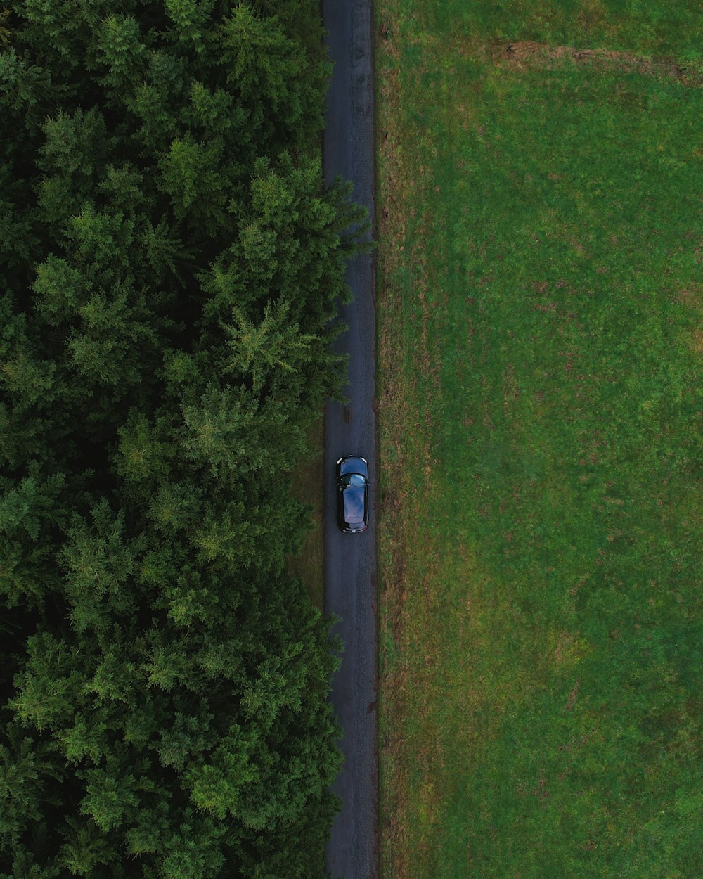 an aerial view of a car parked in the middle of a field