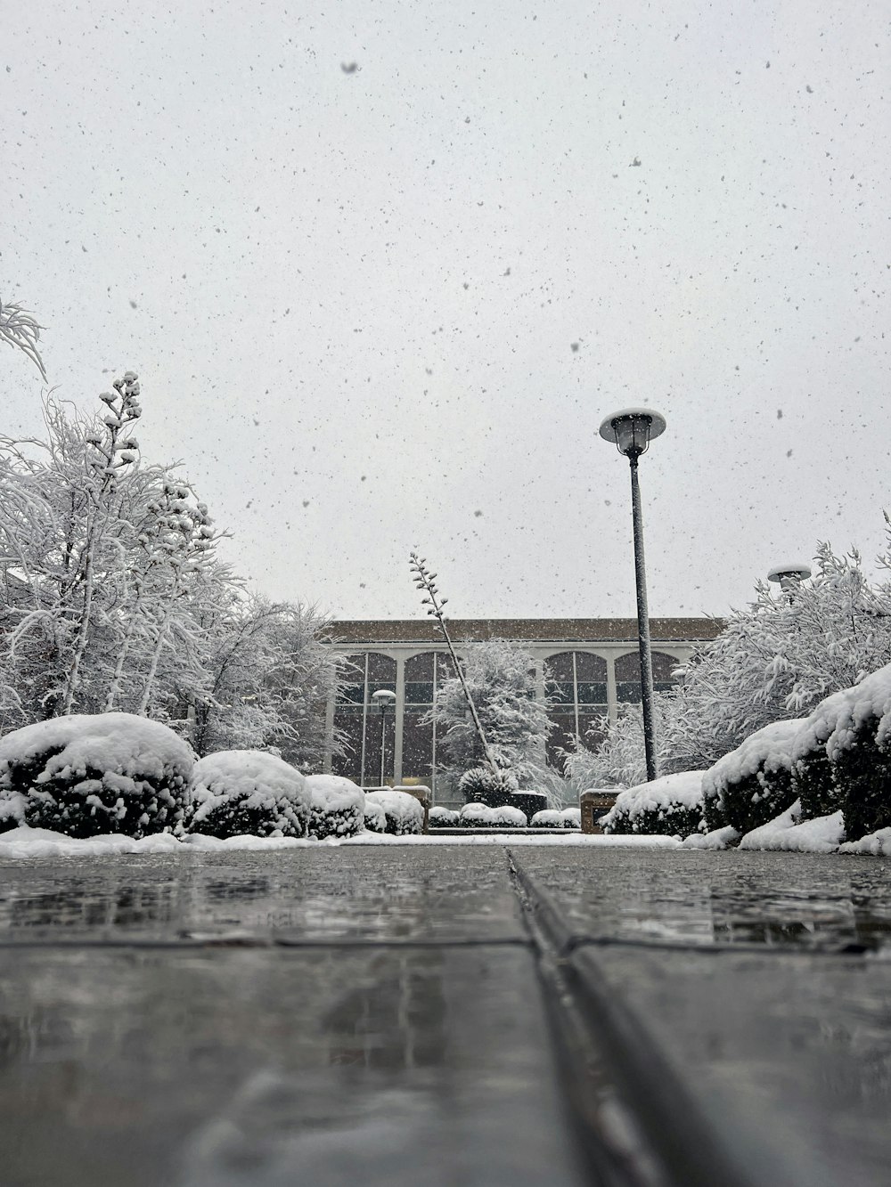 a snow covered parking lot next to a building