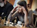 Boy concentrating deeply on a chessboard during a lively Mindspark Academy class.